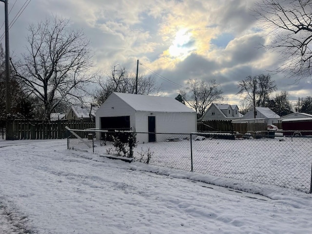 yard layered in snow featuring an outdoor structure and a garage