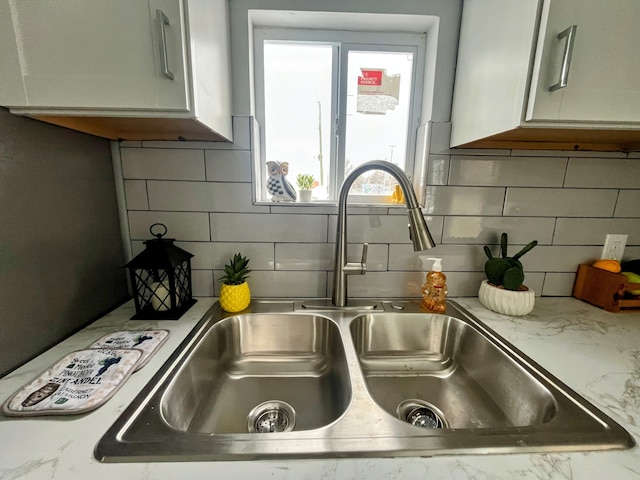 kitchen with light stone countertops, sink, and tasteful backsplash