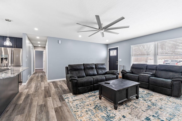 living room with ceiling fan, a textured ceiling, and dark wood-type flooring