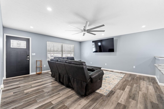 living room featuring ceiling fan, wood-type flooring, and a textured ceiling