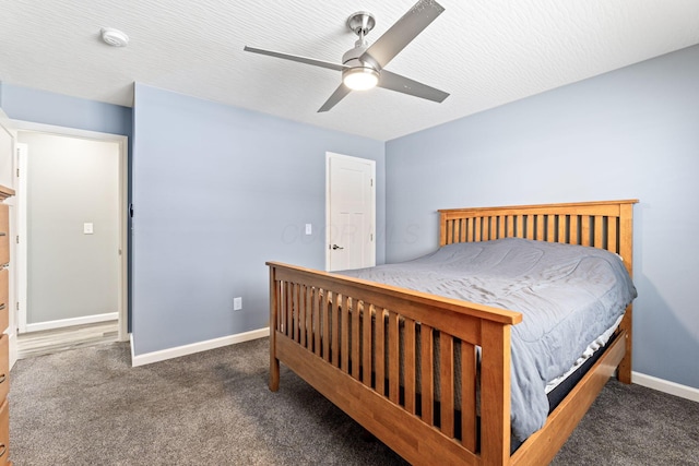 bedroom with ceiling fan, dark carpet, and a textured ceiling