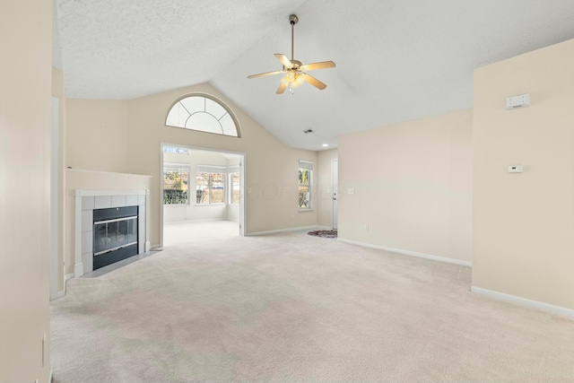 unfurnished living room with ceiling fan, light carpet, a textured ceiling, and a fireplace