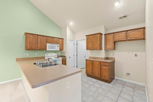 kitchen featuring sink, white appliances, high vaulted ceiling, a textured ceiling, and kitchen peninsula