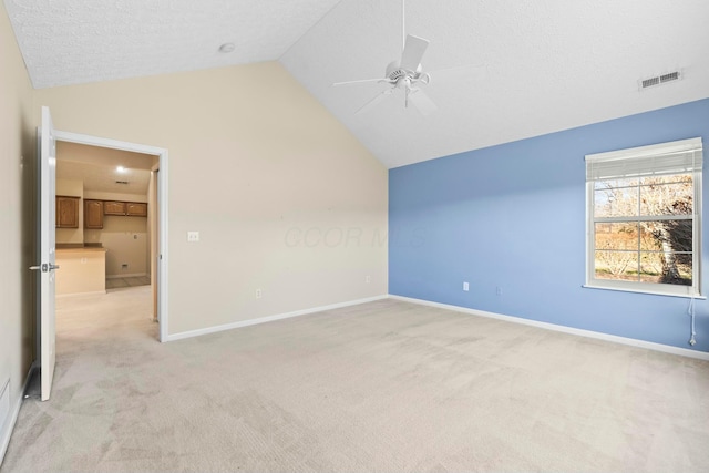 bonus room with light carpet, a textured ceiling, vaulted ceiling, and ceiling fan