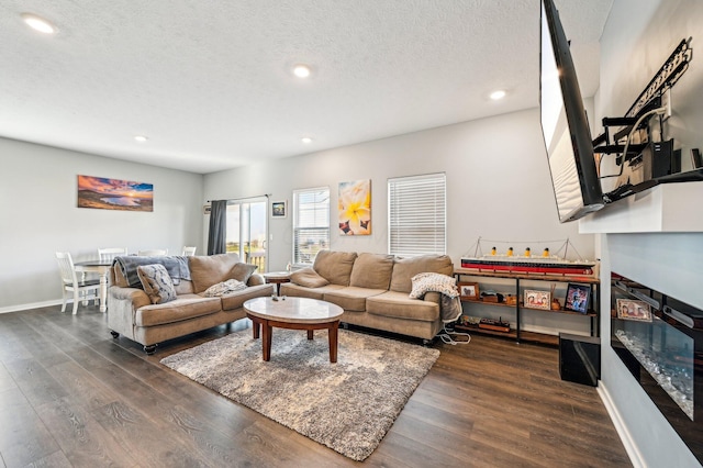 living room with a textured ceiling and dark wood-type flooring