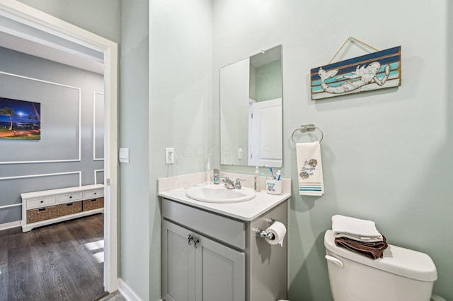 bathroom featuring vanity, hardwood / wood-style flooring, and toilet