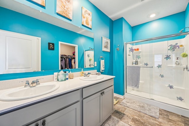 bathroom with vanity and a shower with door