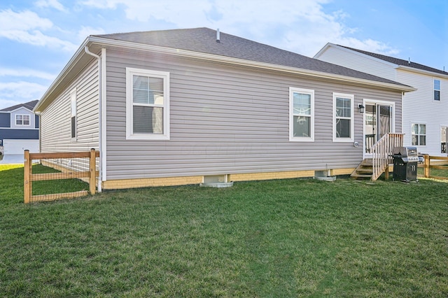 rear view of house featuring a yard