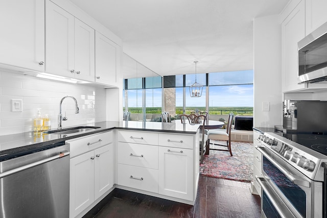 kitchen with stainless steel appliances, sink, decorative light fixtures, white cabinets, and dark hardwood / wood-style floors