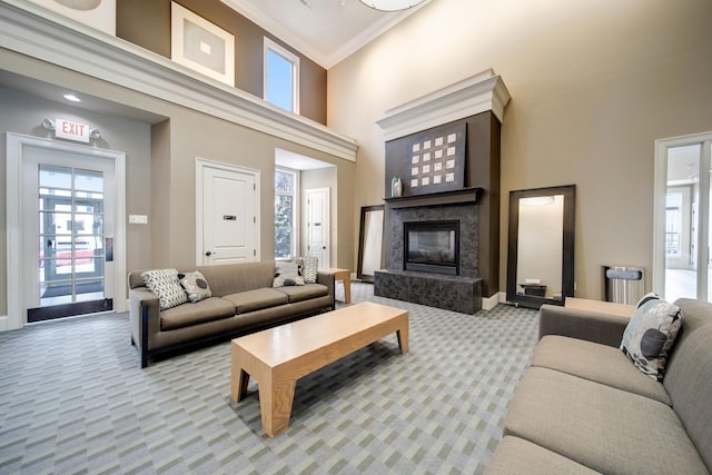 living room featuring a healthy amount of sunlight, a premium fireplace, light carpet, and a high ceiling