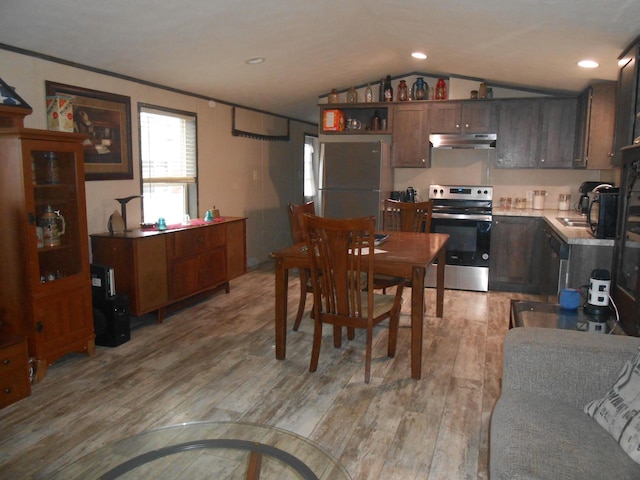 dining room featuring light hardwood / wood-style flooring, vaulted ceiling, and sink