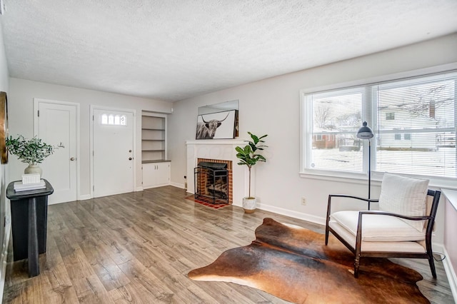 living room featuring hardwood / wood-style flooring, a fireplace, and a textured ceiling