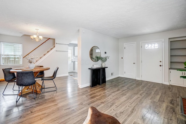 entryway featuring hardwood / wood-style floors, a textured ceiling, and a notable chandelier