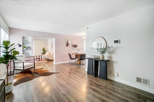 interior space featuring hardwood / wood-style floors, a notable chandelier, and a textured ceiling