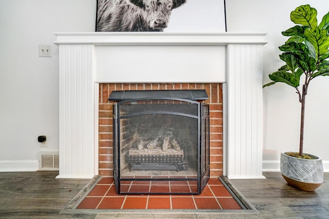 room details featuring a fireplace and wood-type flooring