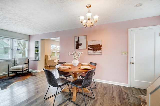 dining space featuring an inviting chandelier, hardwood / wood-style floors, and a textured ceiling