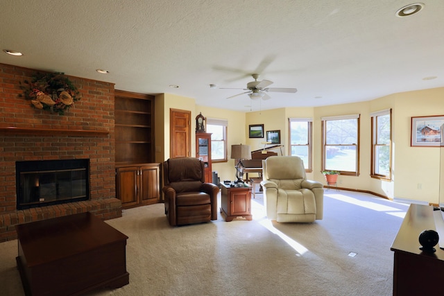 carpeted living room with ceiling fan, a textured ceiling, and a brick fireplace