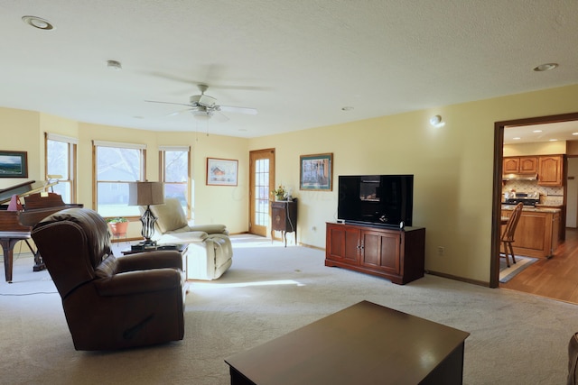 carpeted living room featuring ceiling fan