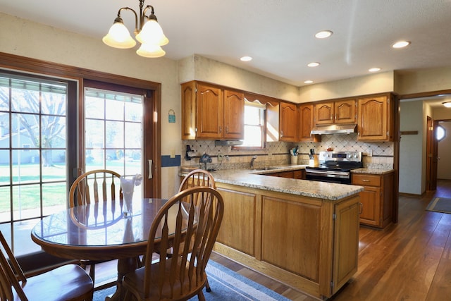 kitchen with sink, dark wood-type flooring, an inviting chandelier, decorative light fixtures, and stainless steel electric stove