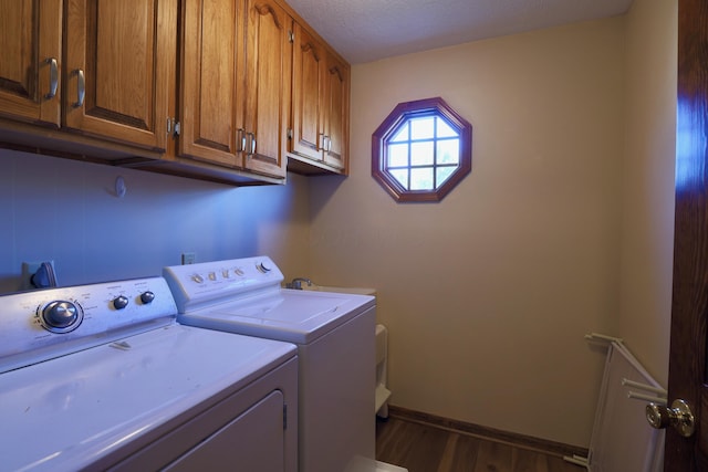 washroom featuring a textured ceiling, cabinets, dark hardwood / wood-style floors, and independent washer and dryer