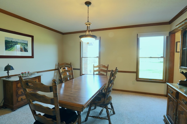 carpeted dining room with ornamental molding