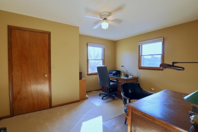 office space featuring ceiling fan, light colored carpet, and a healthy amount of sunlight