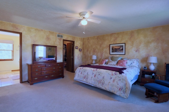 carpeted bedroom featuring ceiling fan, a spacious closet, a textured ceiling, connected bathroom, and a closet