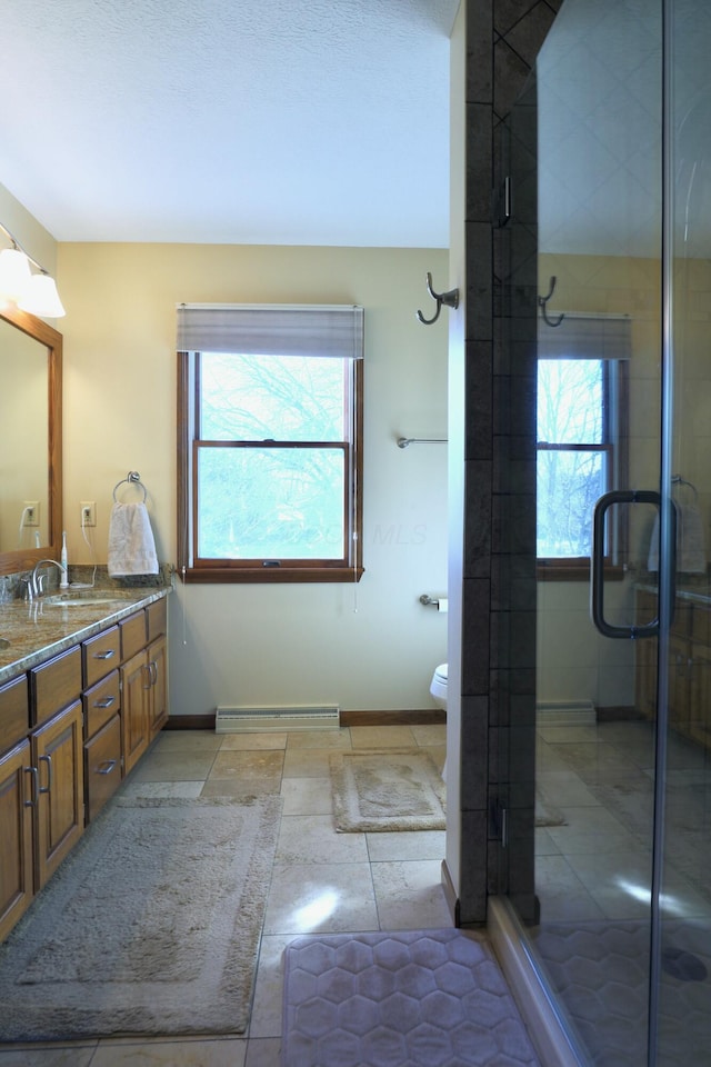 bathroom with an enclosed shower, vanity, toilet, and plenty of natural light