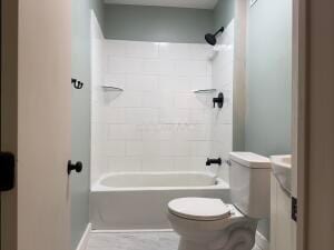 bathroom with shower / bathing tub combination and toilet