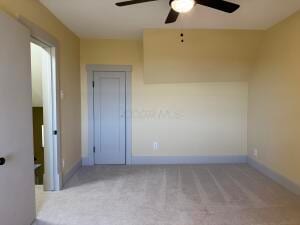 empty room with light colored carpet and ceiling fan