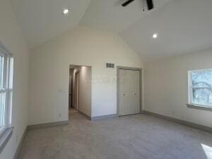 unfurnished bedroom with ceiling fan and lofted ceiling