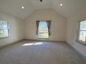 unfurnished room with carpet and vaulted ceiling