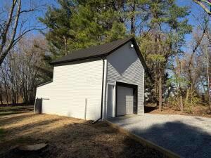 view of side of home featuring an outbuilding and a garage