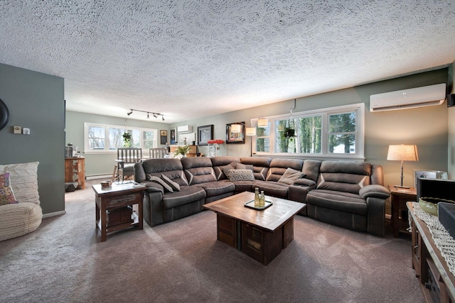 living room featuring a textured ceiling, dark colored carpet, rail lighting, and an AC wall unit