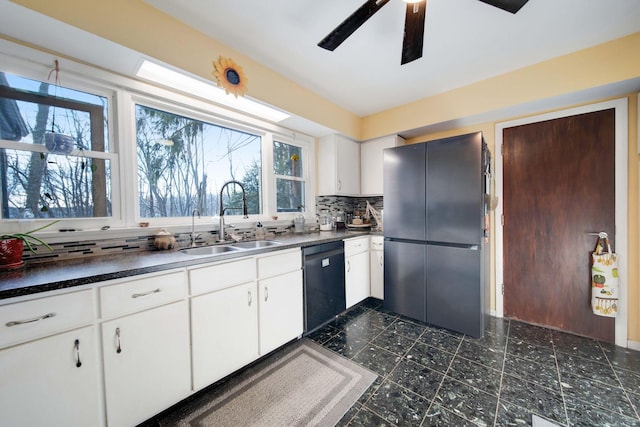 kitchen featuring white cabinets, black dishwasher, tasteful backsplash, sink, and stainless steel fridge