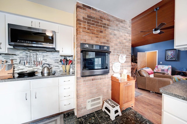 kitchen featuring gas cooktop, wooden ceiling, backsplash, oven, and white cabinets