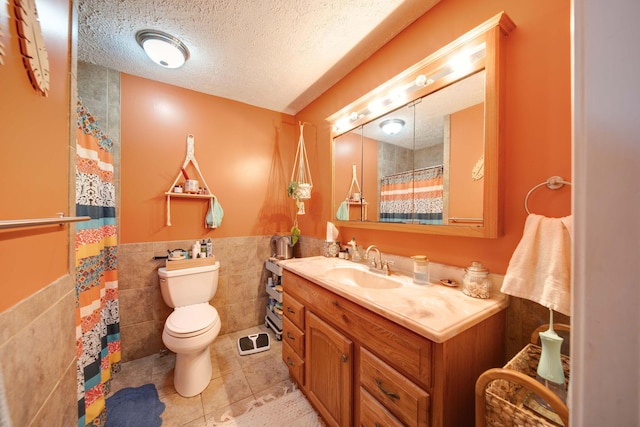 bathroom featuring toilet, a shower with shower curtain, tile walls, a textured ceiling, and vanity