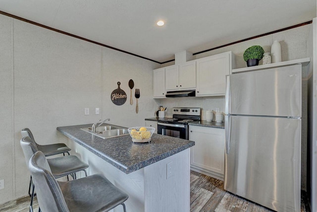 kitchen with white cabinets, appliances with stainless steel finishes, light wood-type flooring, and sink