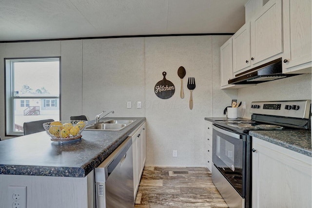 kitchen with stainless steel appliances, dark wood-type flooring, sink, white cabinetry, and a kitchen island