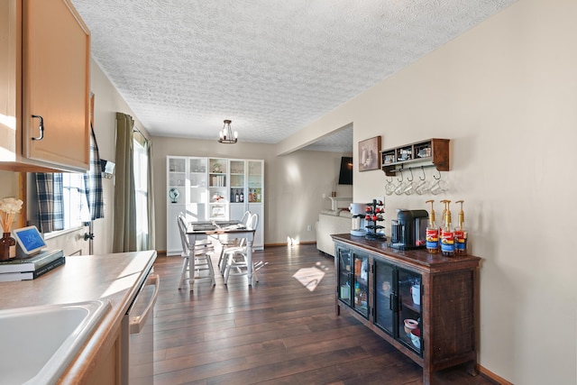 kitchen with dishwasher, dark wood-type flooring, a textured ceiling, and sink