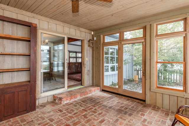 unfurnished sunroom with ceiling fan and wooden ceiling