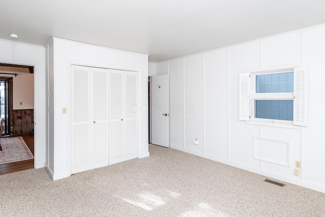 unfurnished bedroom with light carpet and a closet