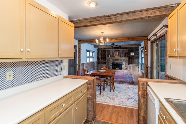 kitchen featuring hanging light fixtures, hardwood / wood-style flooring, dishwasher, a notable chandelier, and beamed ceiling