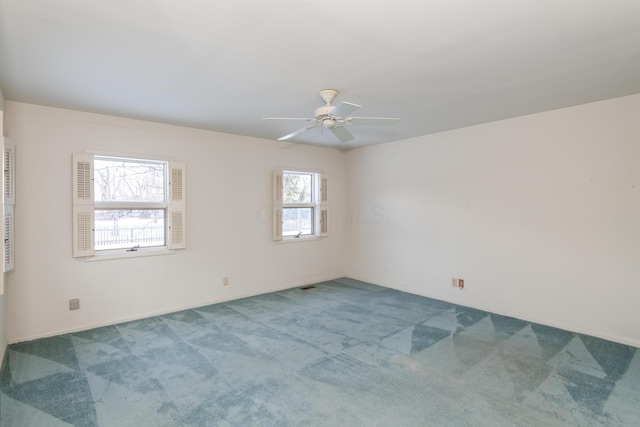 carpeted spare room with ceiling fan