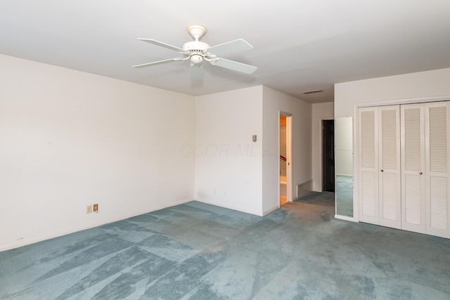 unfurnished bedroom featuring ensuite bathroom, a closet, ceiling fan, and dark colored carpet