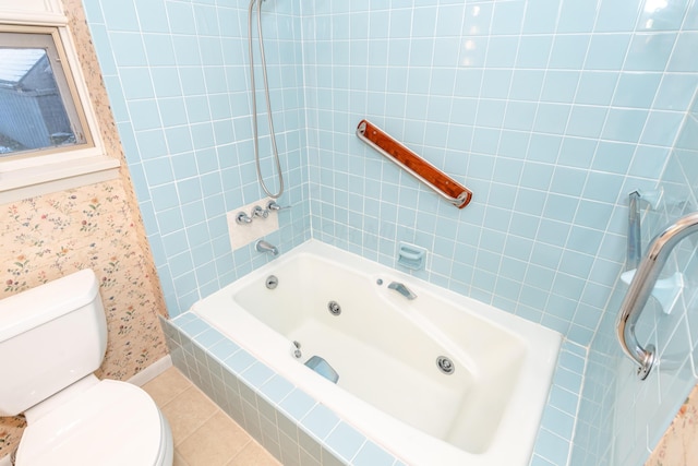 bathroom with tiled shower / bath combo, tile patterned floors, and toilet