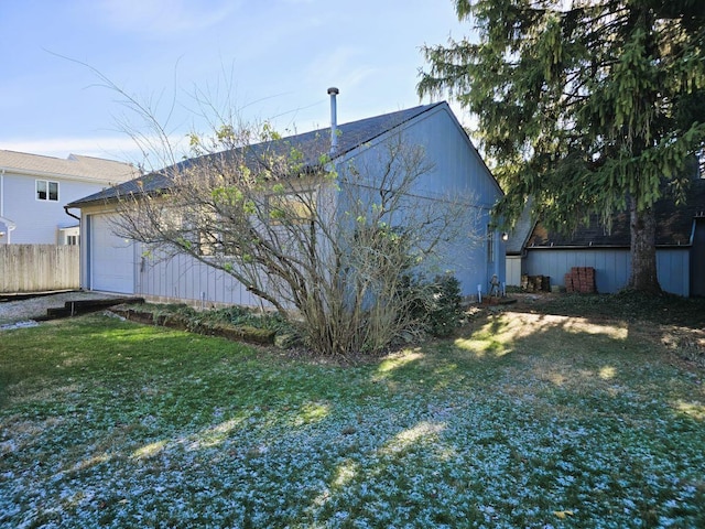 back of property featuring a garage and a yard