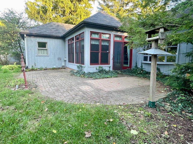 back of property with a patio area and a sunroom