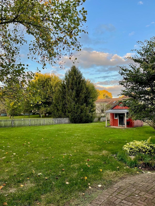 yard at dusk featuring an outbuilding