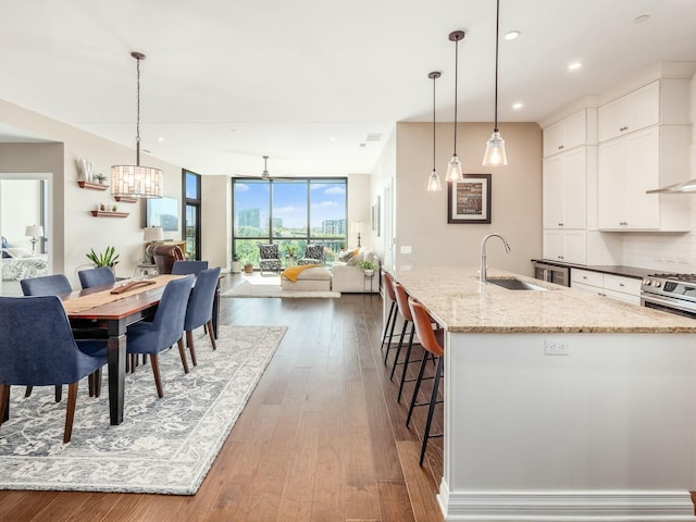 kitchen featuring hanging light fixtures, white cabinets, sink, and a spacious island